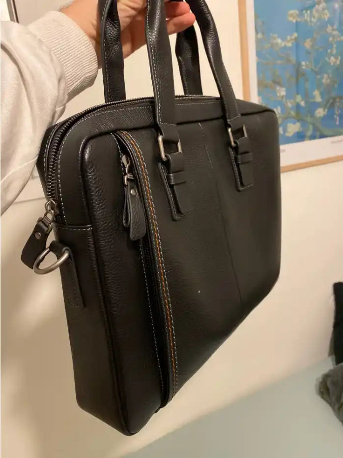 Attaché-case en cuir noir avec des accessoires en acier inoxydable.